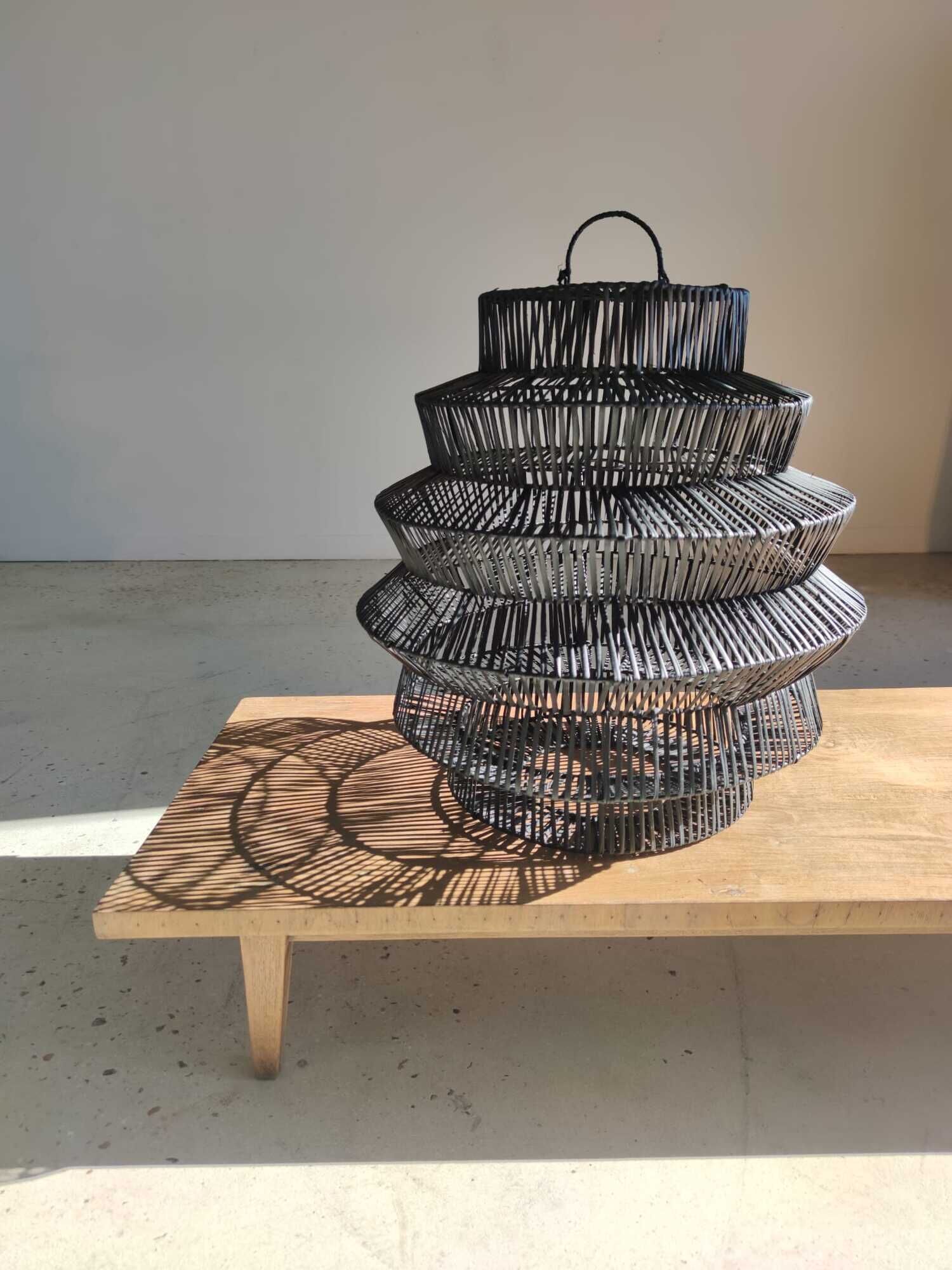 Braided rattan suspension in the shape of a black accordion