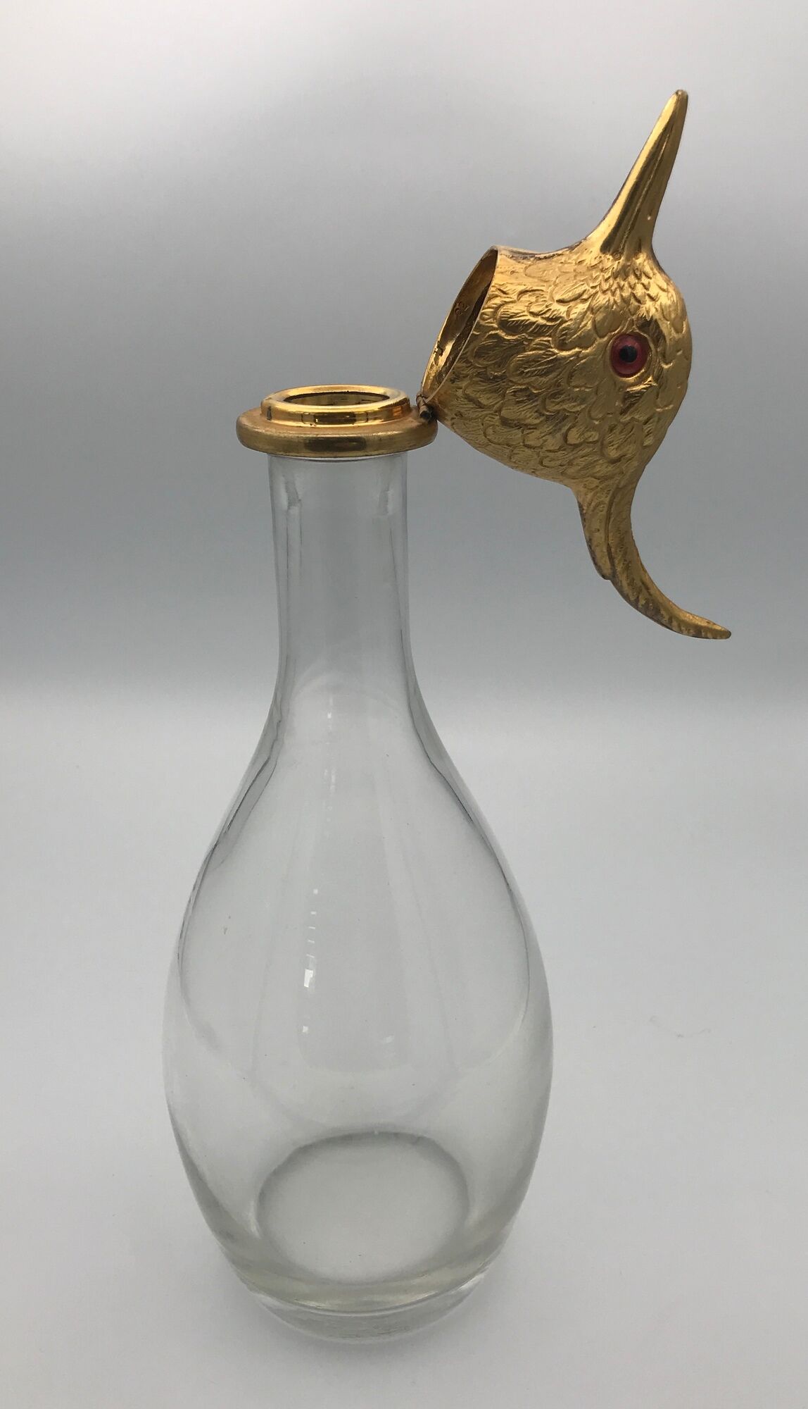 Glass bottle type carafe with gold metal bird head stopper