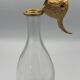 Glass bottle type carafe with gold metal bird head stopper