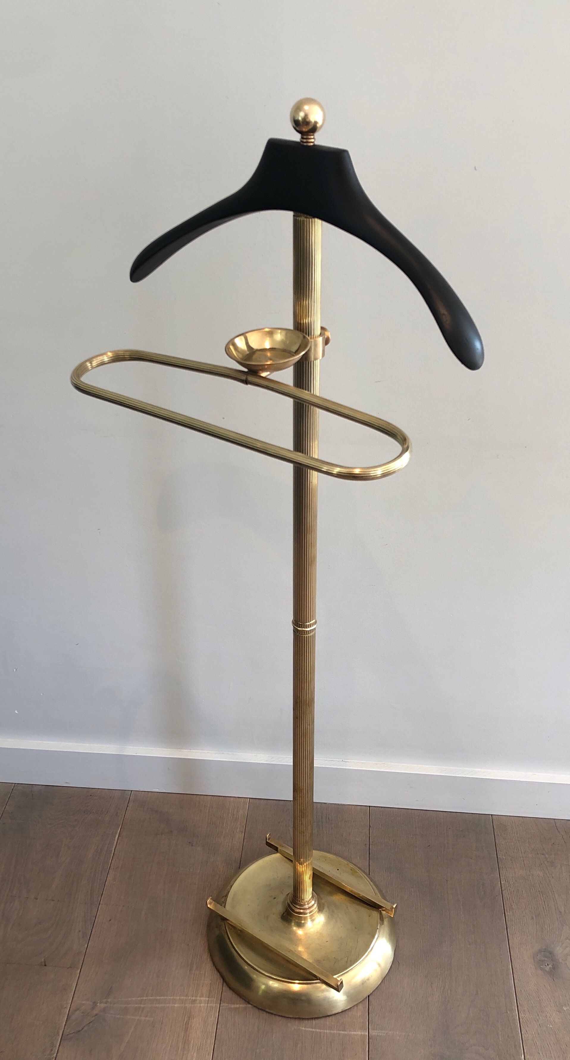 Neoclassical style valet stand in brass and black lacquered wood. French work. Circa 1940