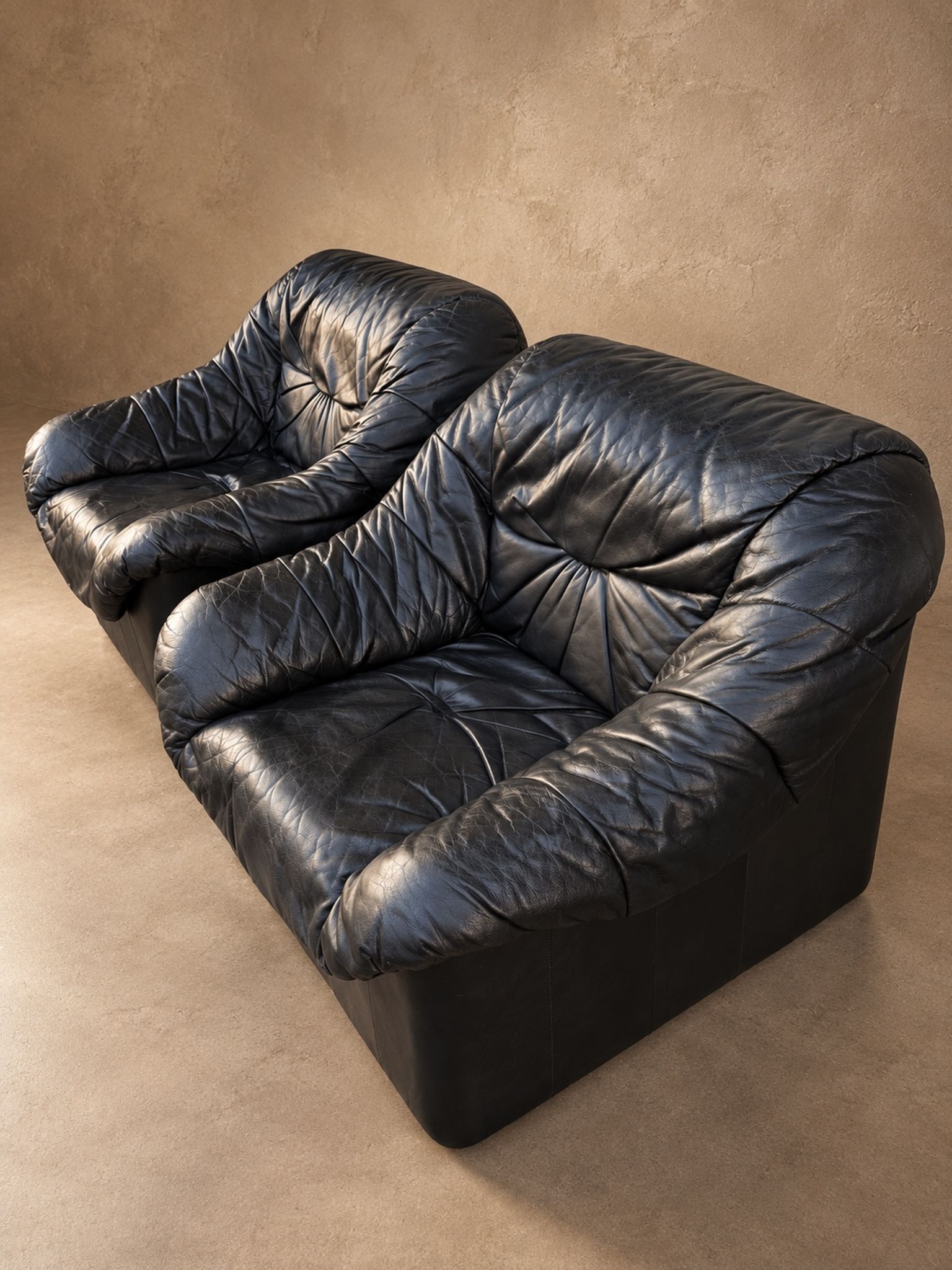 Leather armchairs and matching pouf, Italy, circa 1980