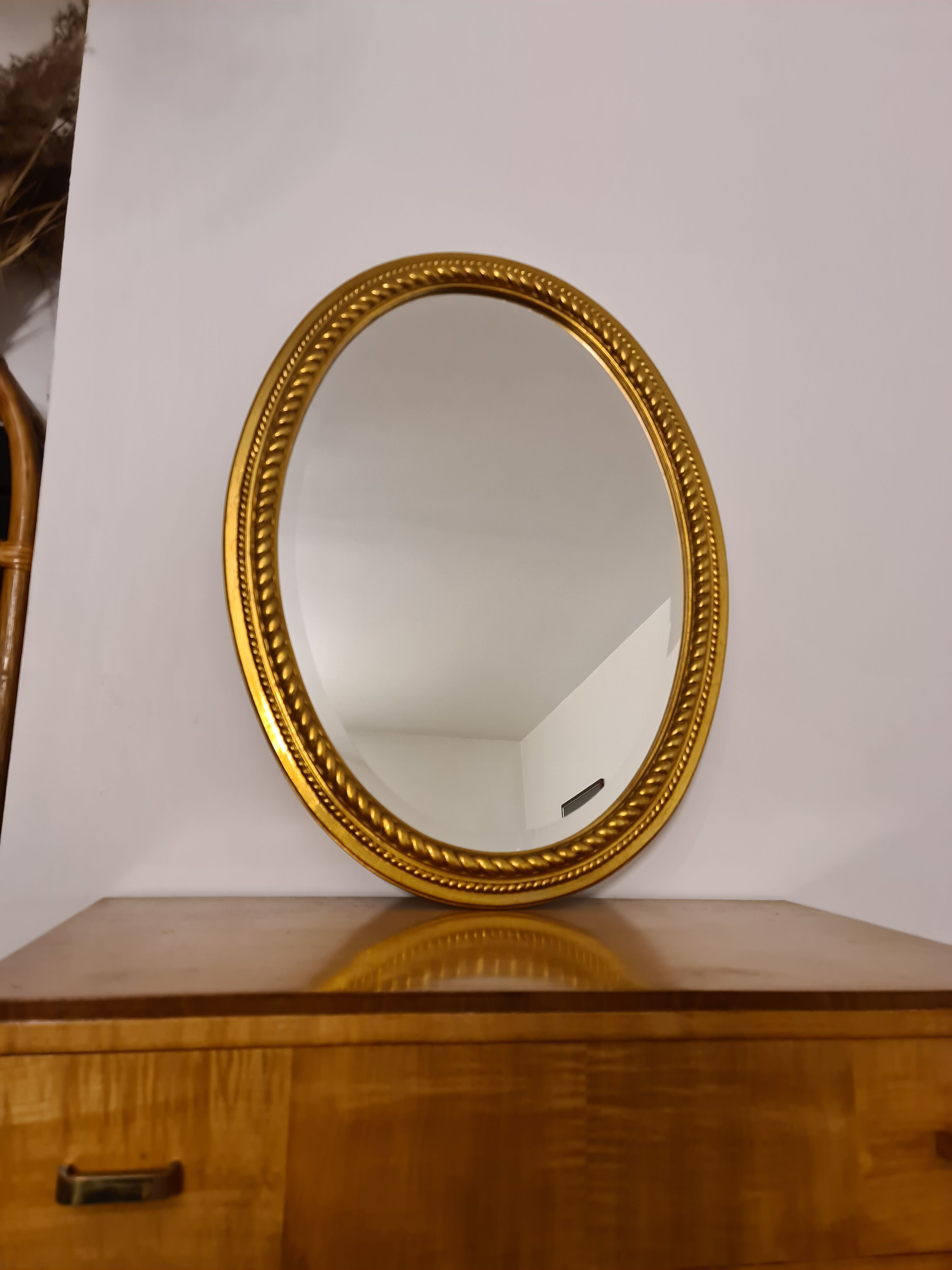 Beveled oval mirror in gilded wood 78×58cm