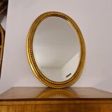 Beveled oval mirror in gilded wood 78×58cm