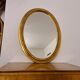 Beveled oval mirror in gilded wood 78×58cm