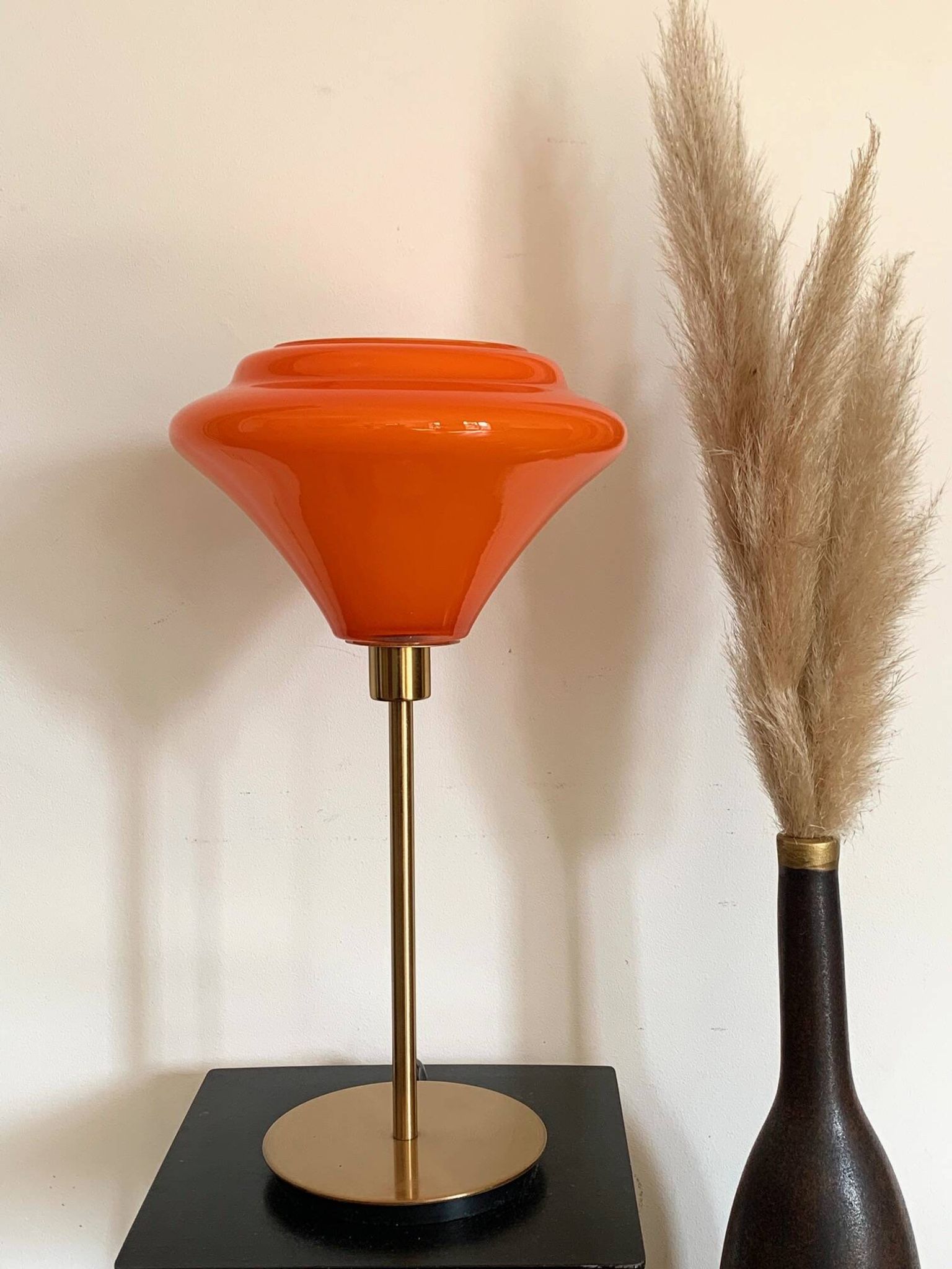 Table lamp with a vintage orange glass globe and a gold base