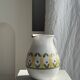 Large white terracotta carafe with a stylized green and yellow frieze pattern