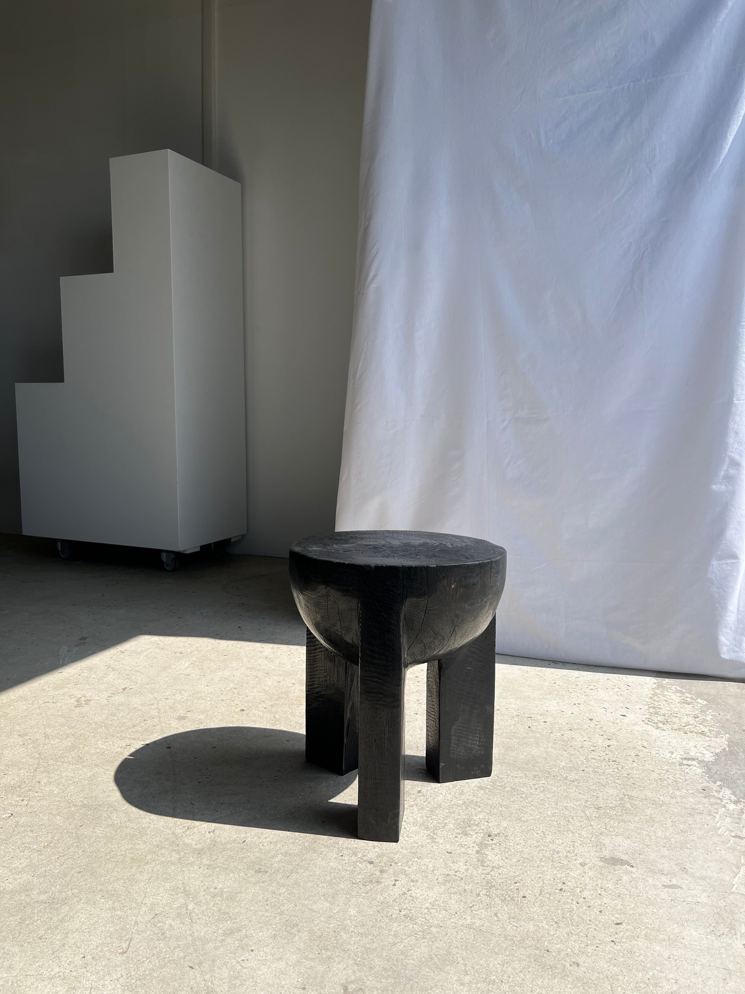 Black mango wood tripod side table with a semi-spherical top, height: 45 cm, diameter: 44 cm.