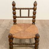 Low chair in beaded wood and straw