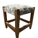 Square pouf with a checkered pattern.