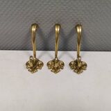 Three old and beautiful brass hooks with decorative motifs