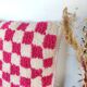 Berber cushion with a pink checkerboard pattern.
