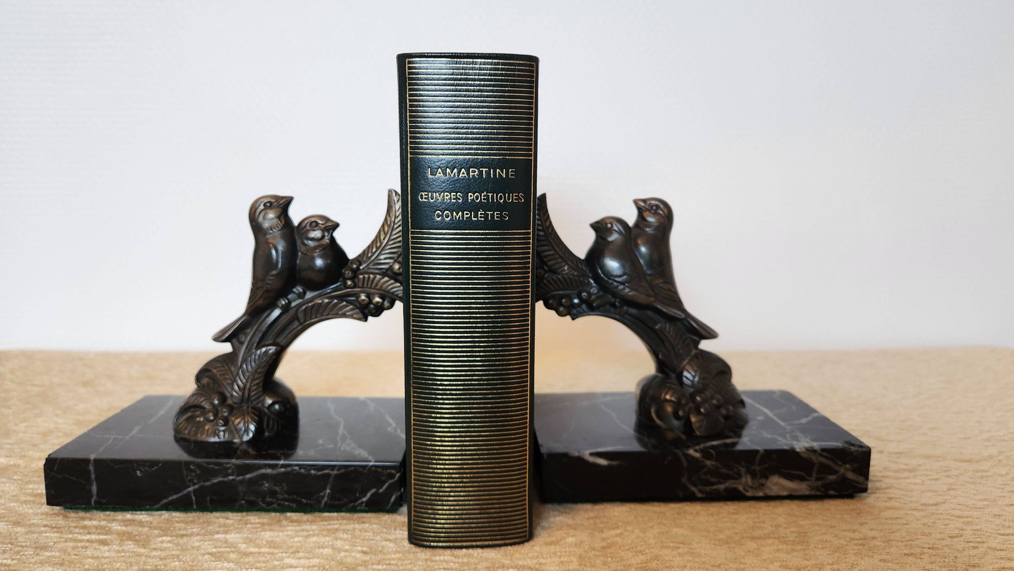 Pair of Art Deco bookends signed Frécourt, patinated metal & black marble