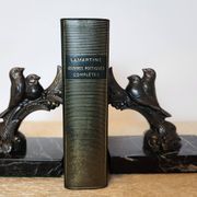 Pair of Art Deco bookends signed Frécourt, patinated metal & black marble