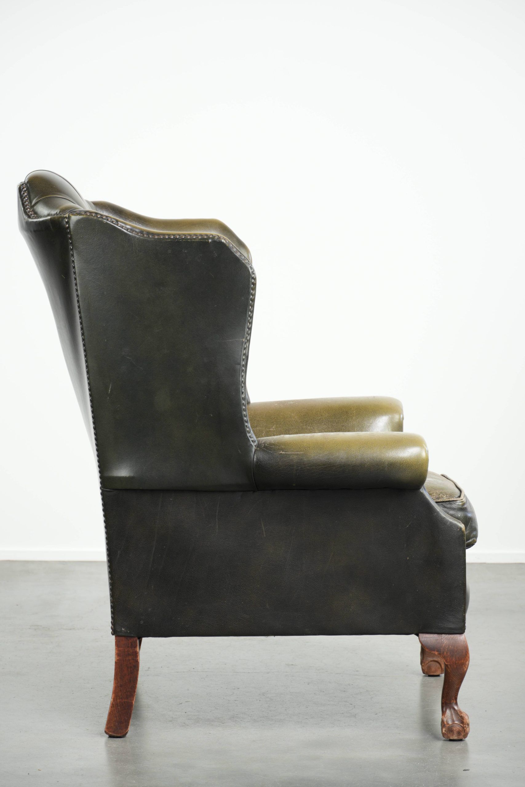 Vintage cowhide leather Chesterfield wingback armchair in a green colour