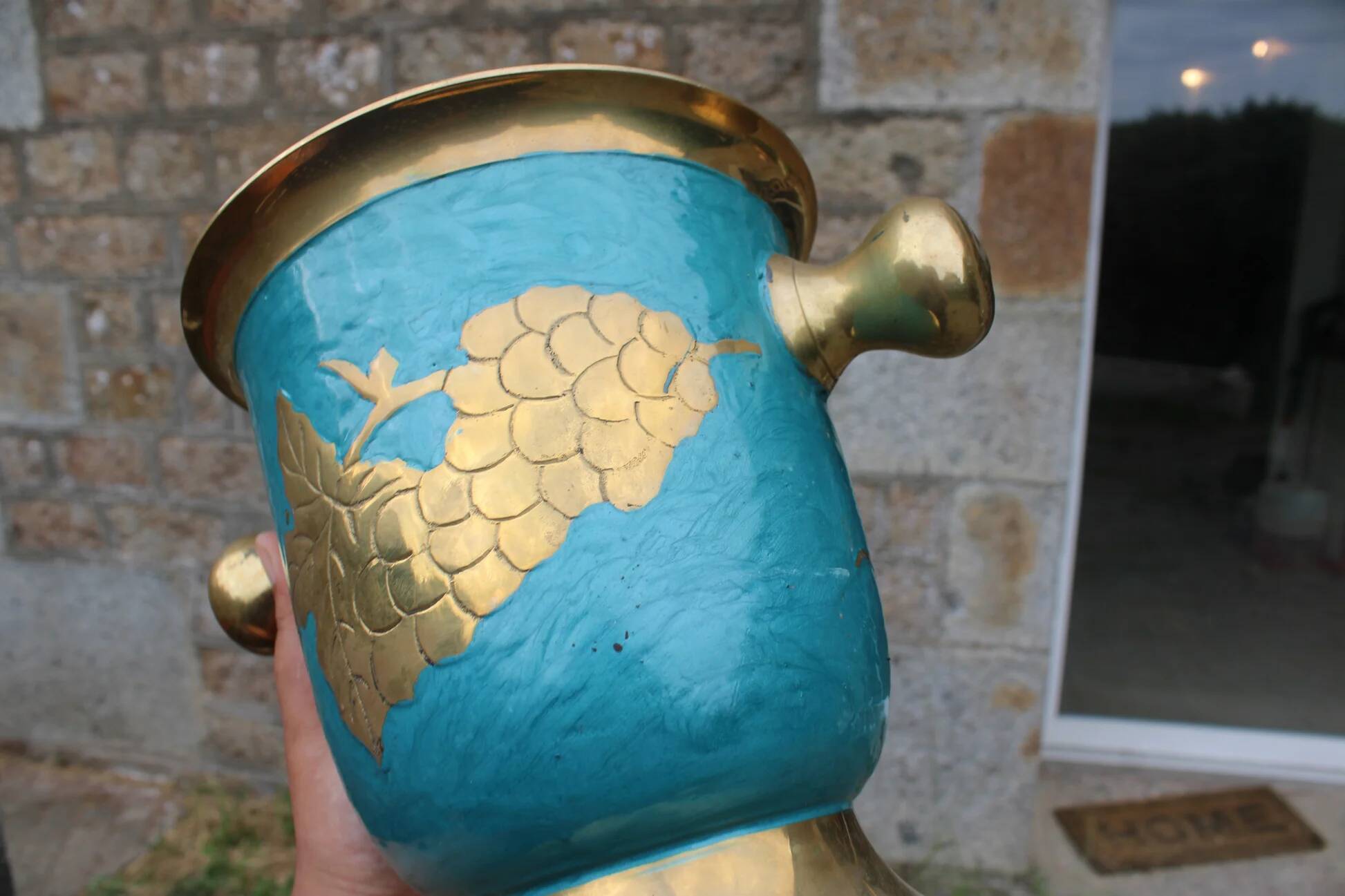 Vintage turquoise brass champagne bucket with grape decoration.