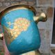 Vintage turquoise brass champagne bucket with grape decoration.