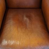 Cognac-colored sheepskin armchair with rounded shapes