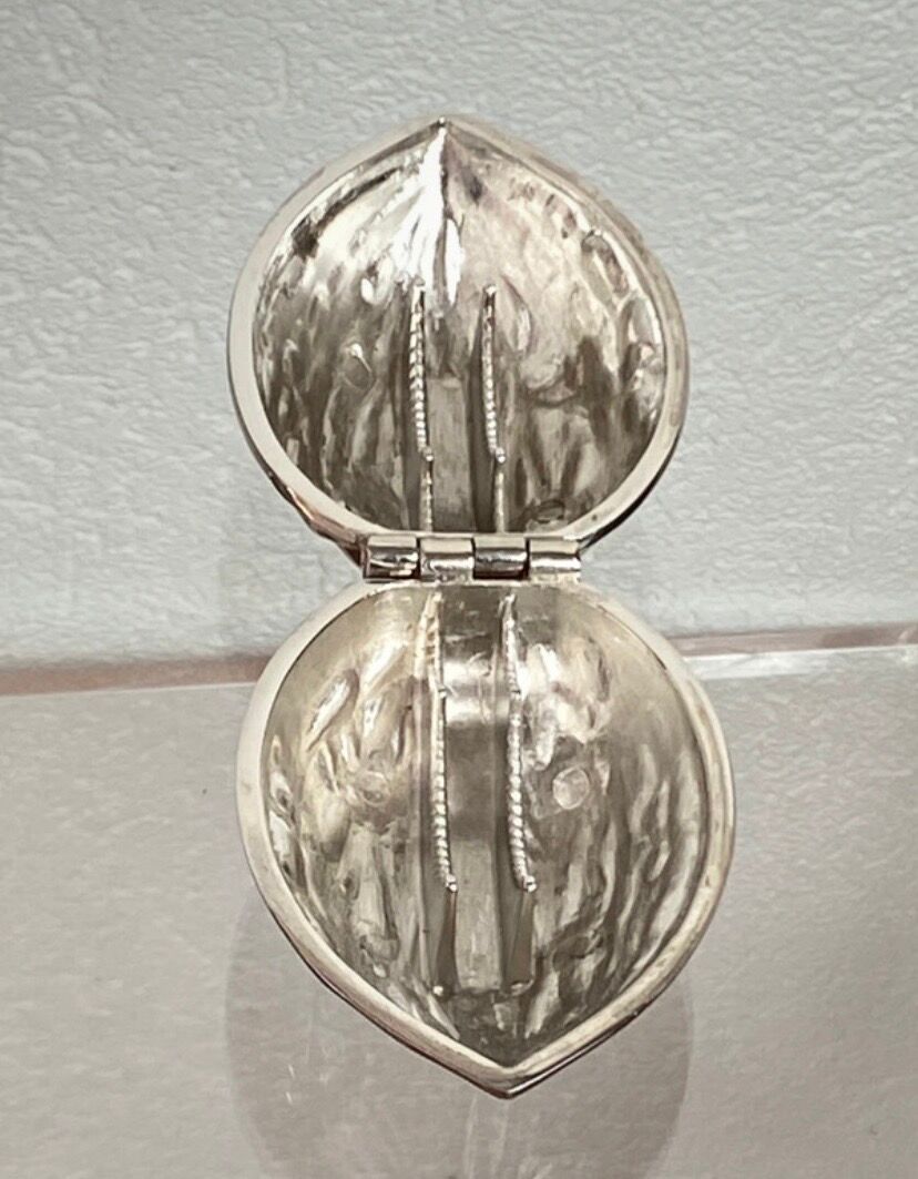 Nutcracker in the shape of a nut in silver-plated metal.