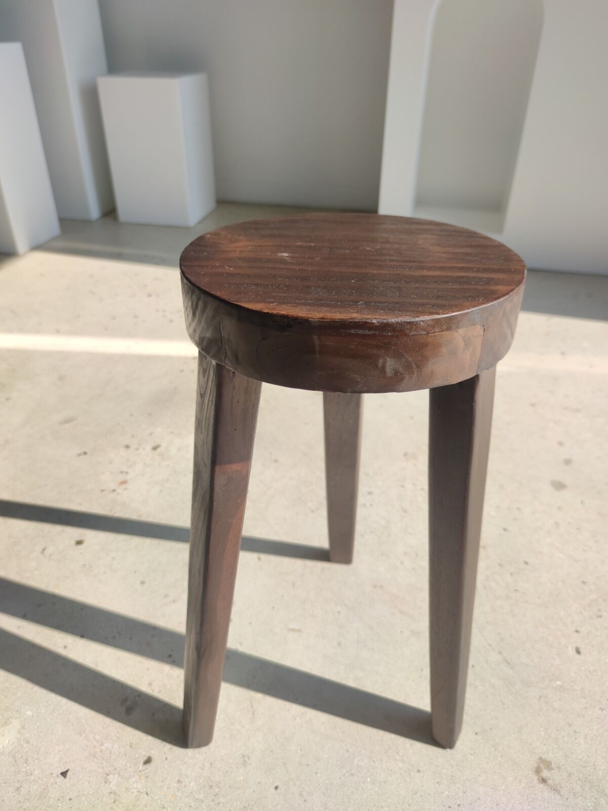 Small high tripod stool in brown solid wood