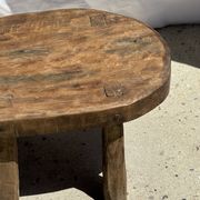 Small stool, oval solid teak side table with curved legs in wabi-sabi style.