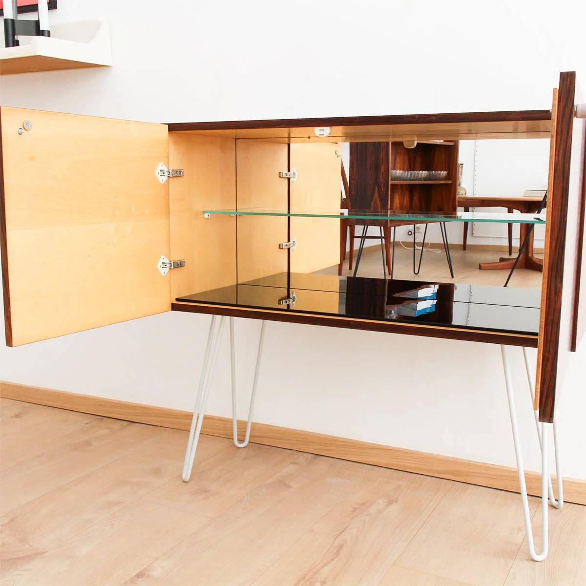 Buffet en palissandre avec des pieds en métal gris clair en forme de épingle.