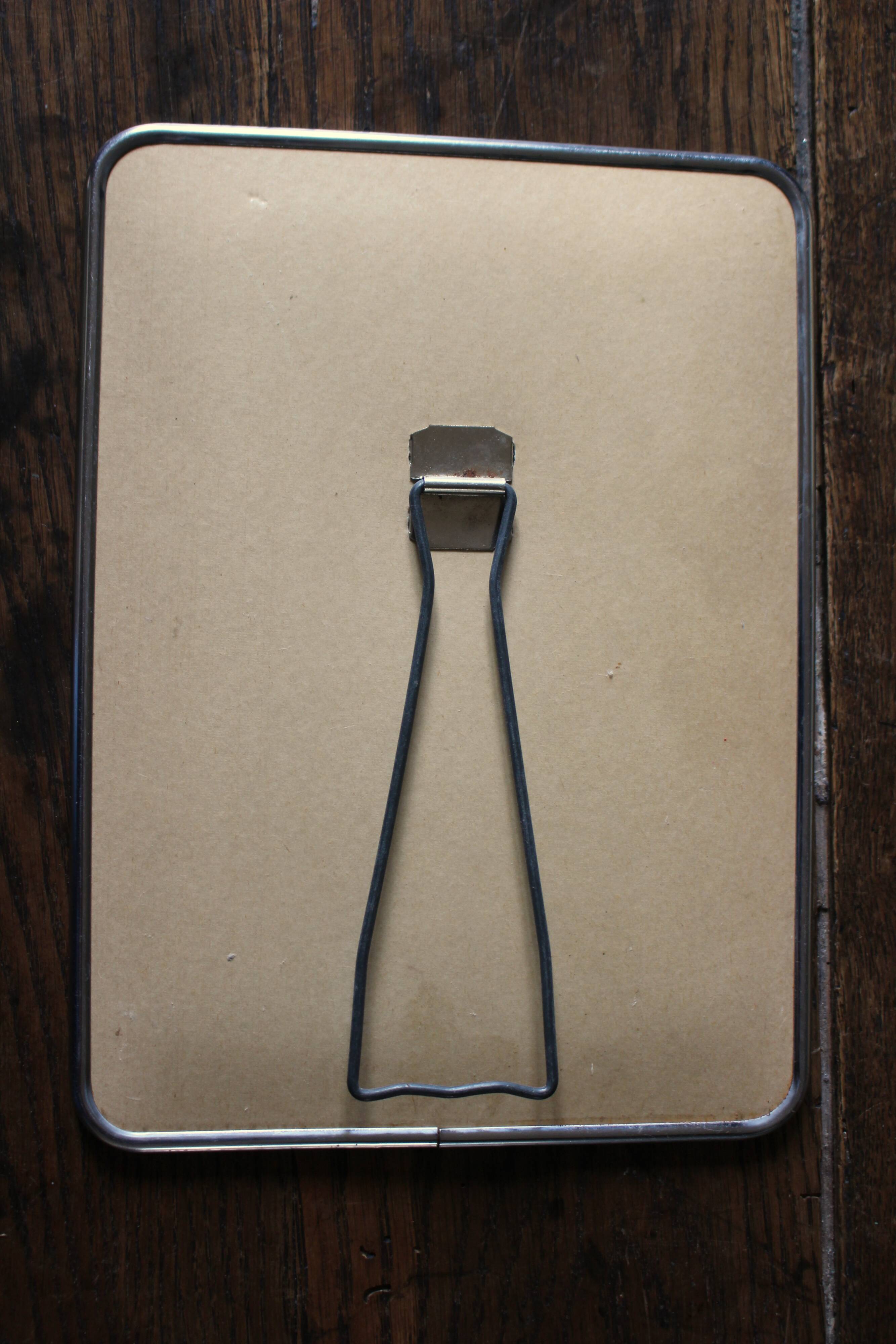 Simple rectangular barber mirror with a stand.