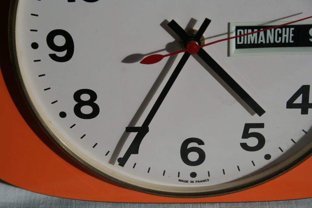 Vintage wall clock in orange formica