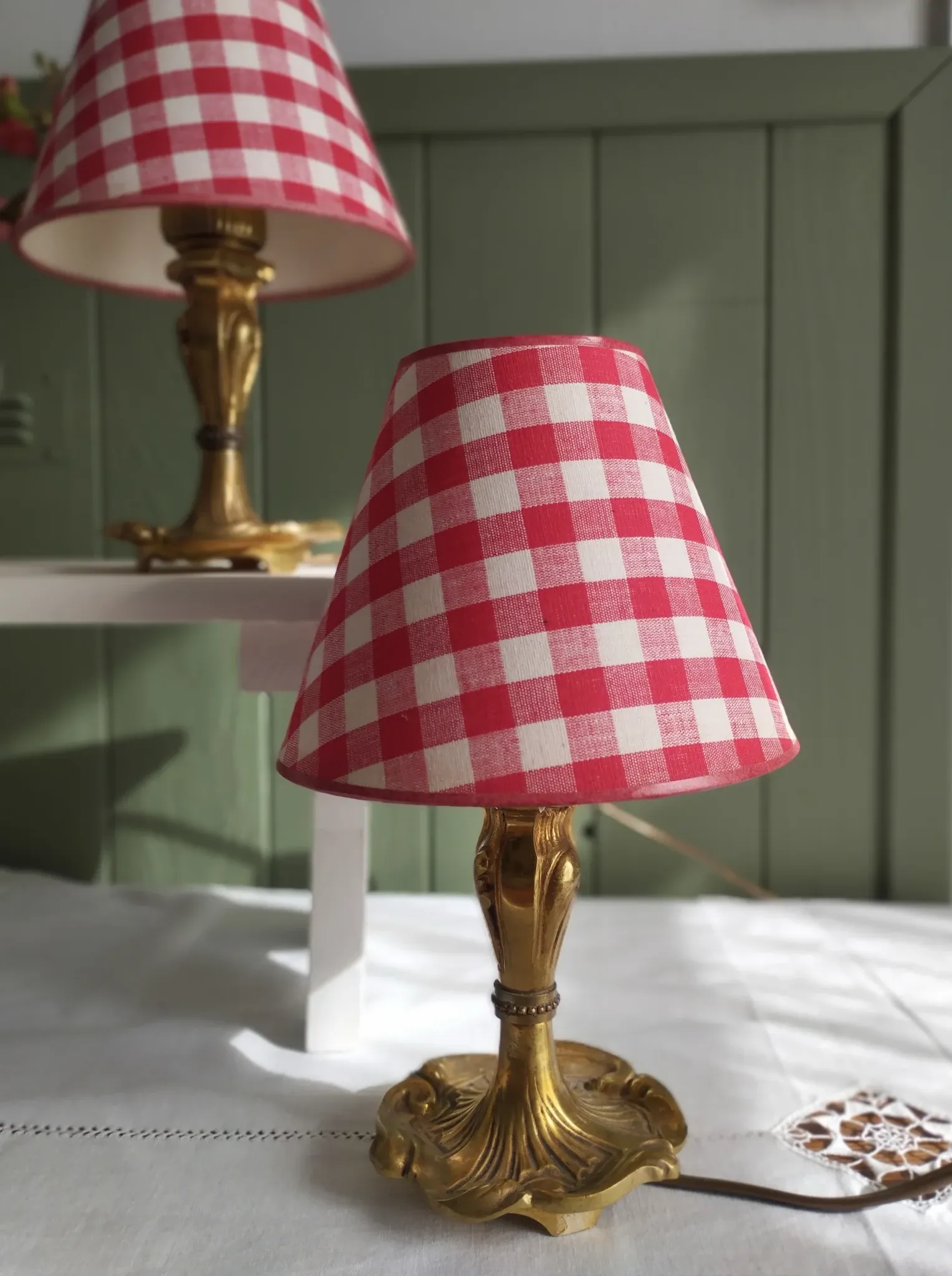 Pair of small lamps in gilded bronze by Petitot and red gingham lampshades.