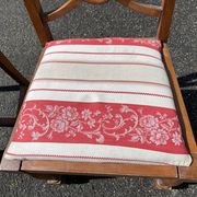 Pair of antique walnut chairs with rose design and red striped cushions.