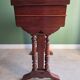 Antique wooden sewing cabinet with mirror and storage.
