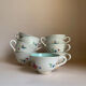 Set of 9 floral Luneville porcelain coffee cups with gold edges