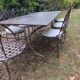 Old wrought iron table and its armchairs and chairs for outdoor use.