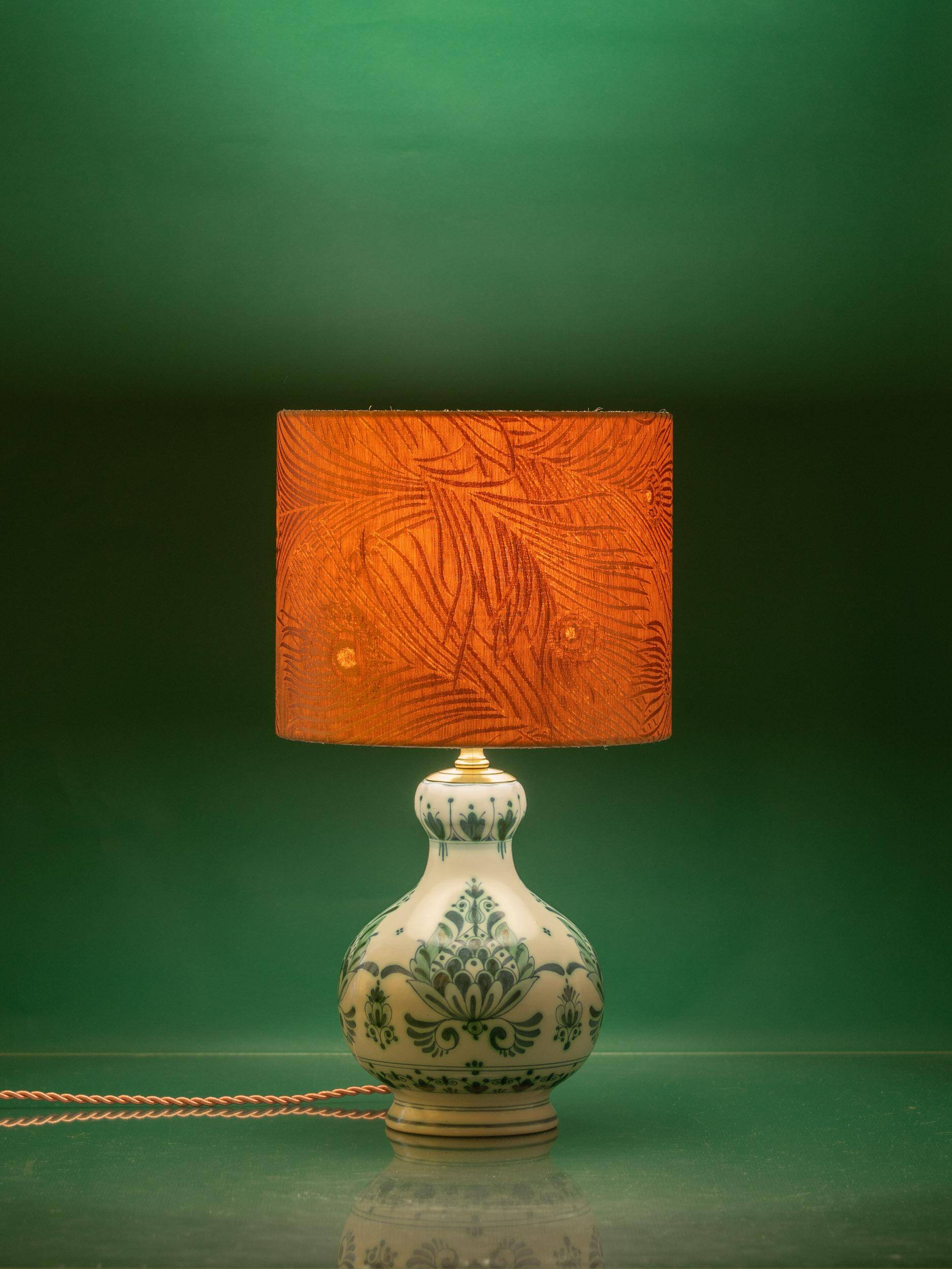 Royal Delft blue-green ceramic table lamp with pink jacquard peacock shade.