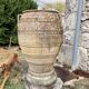 Large Cretan jar in terracotta with three handles on a stone base.
