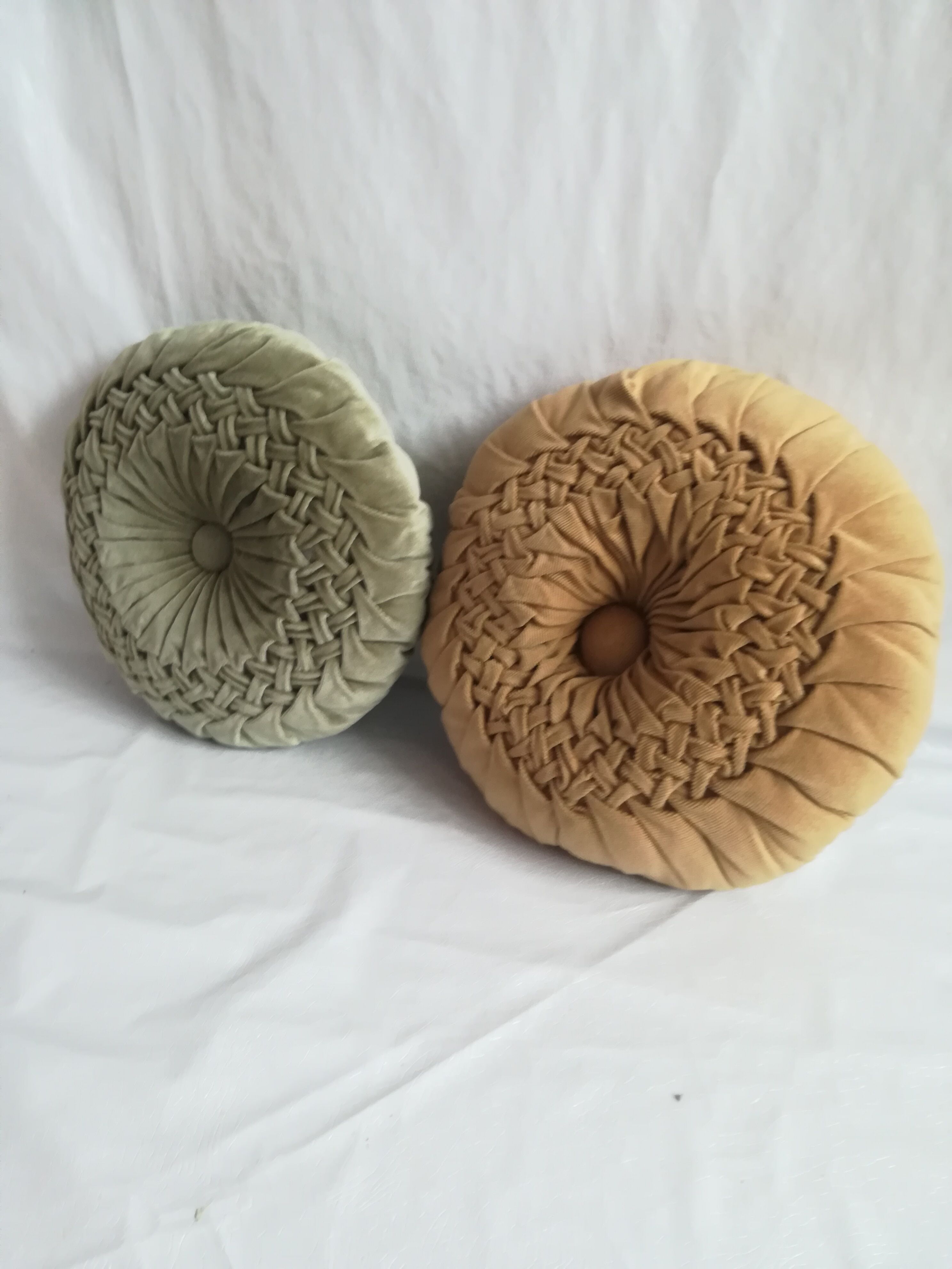 Pair of round pleated velvet cushions