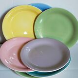 Seven pastel-colored plates mixed with vintage earthenware