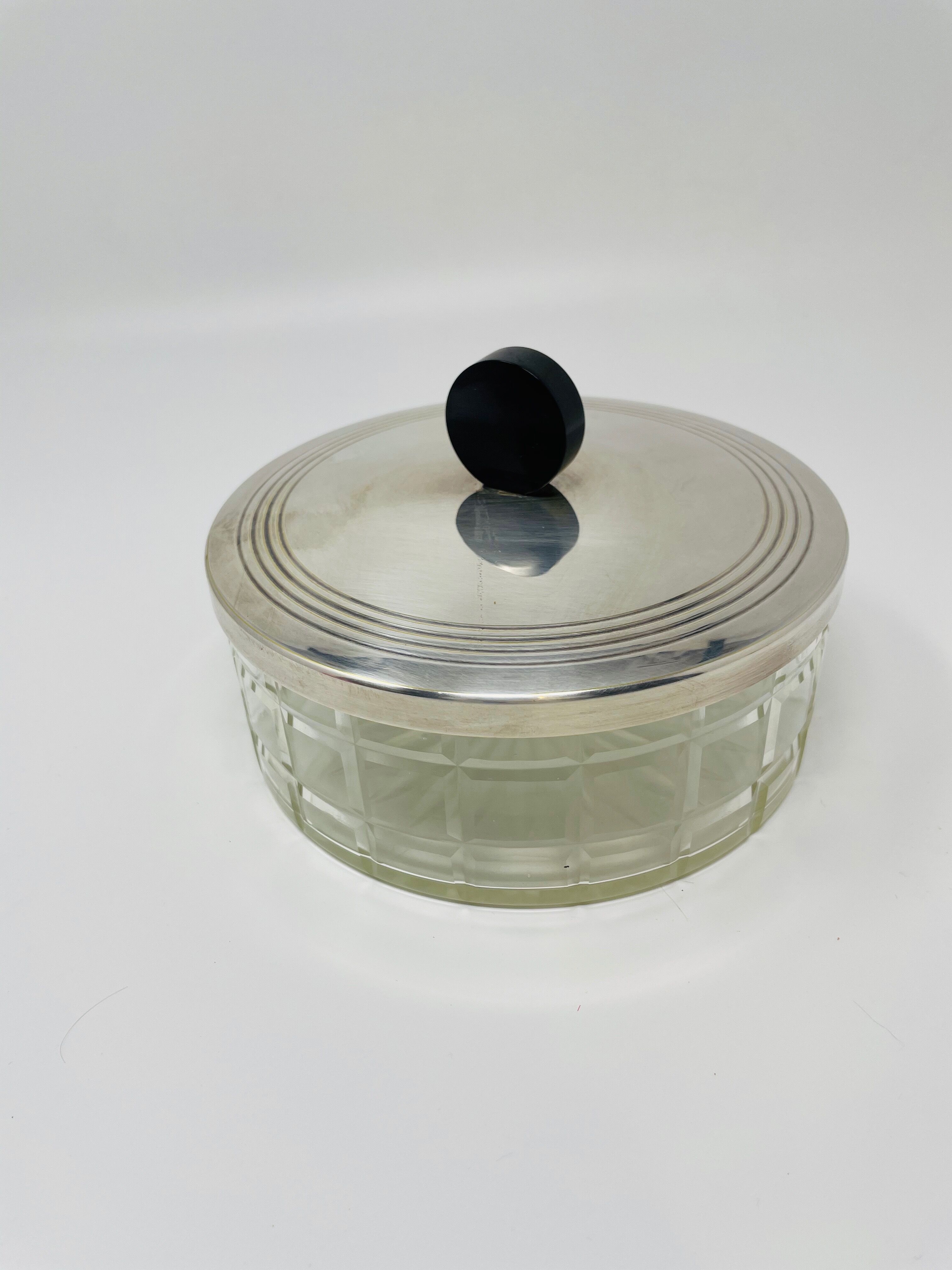 Vintage box made of chiseled glass and covered metal, taken in black Bakelite