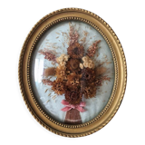 Golden vintage frame with bouquet of dried flowers under globe, wedding bouquet, antique bouquet