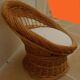 Wicker armchair with a high back and its boucle fabric cushion.
