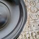 Shallow round metal plate with pearl row decoration.