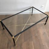 Brass coffee table upholstered in black leather. In the style of Jacques Adnet.