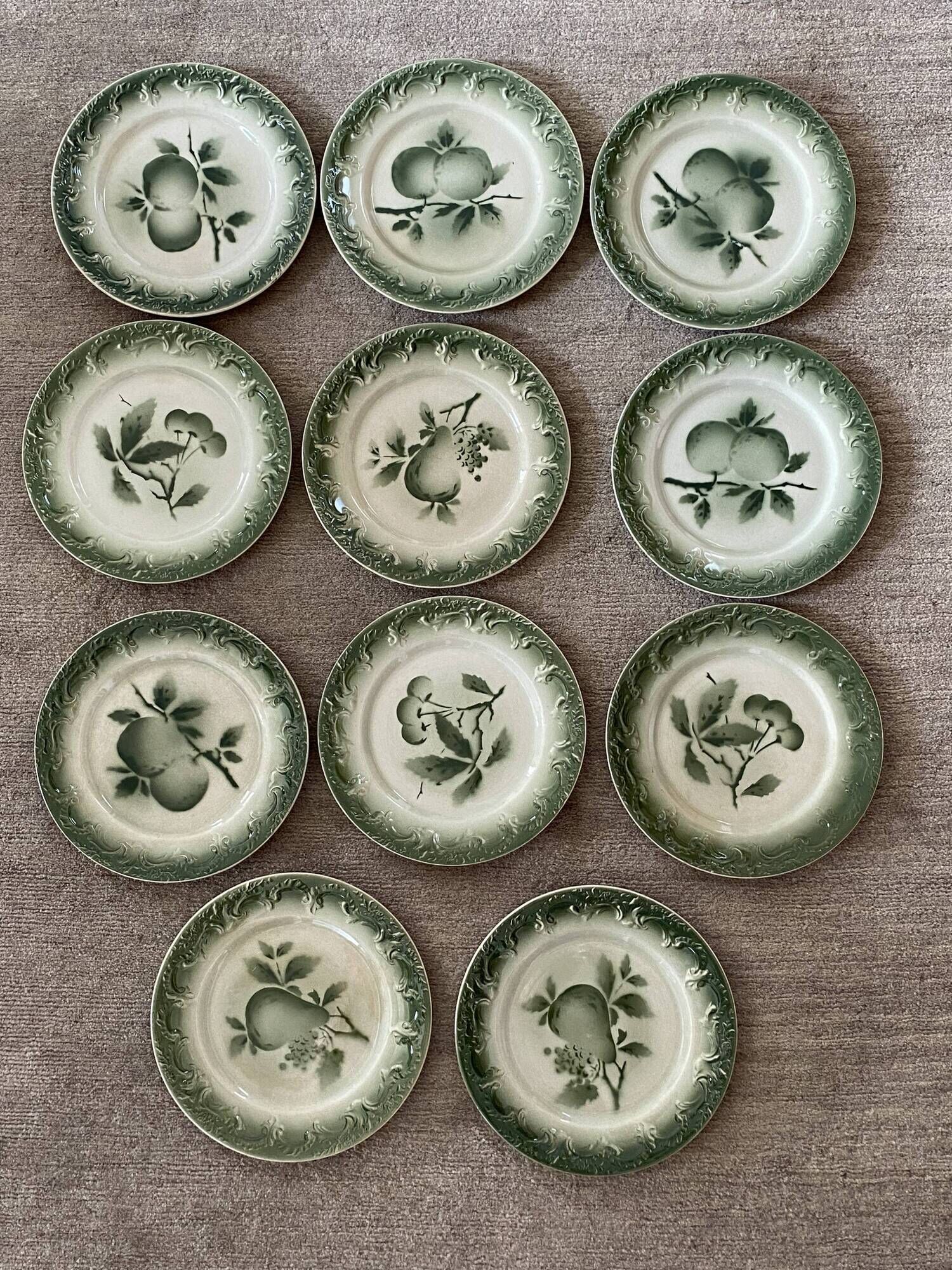 11 old dessert plates from the Pexonne earthenware factory, green and cream fruit decoration
