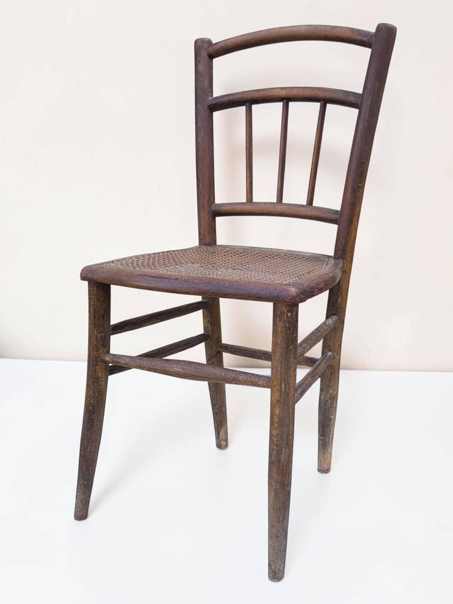 Chair with a slatted backrest and caned seat.