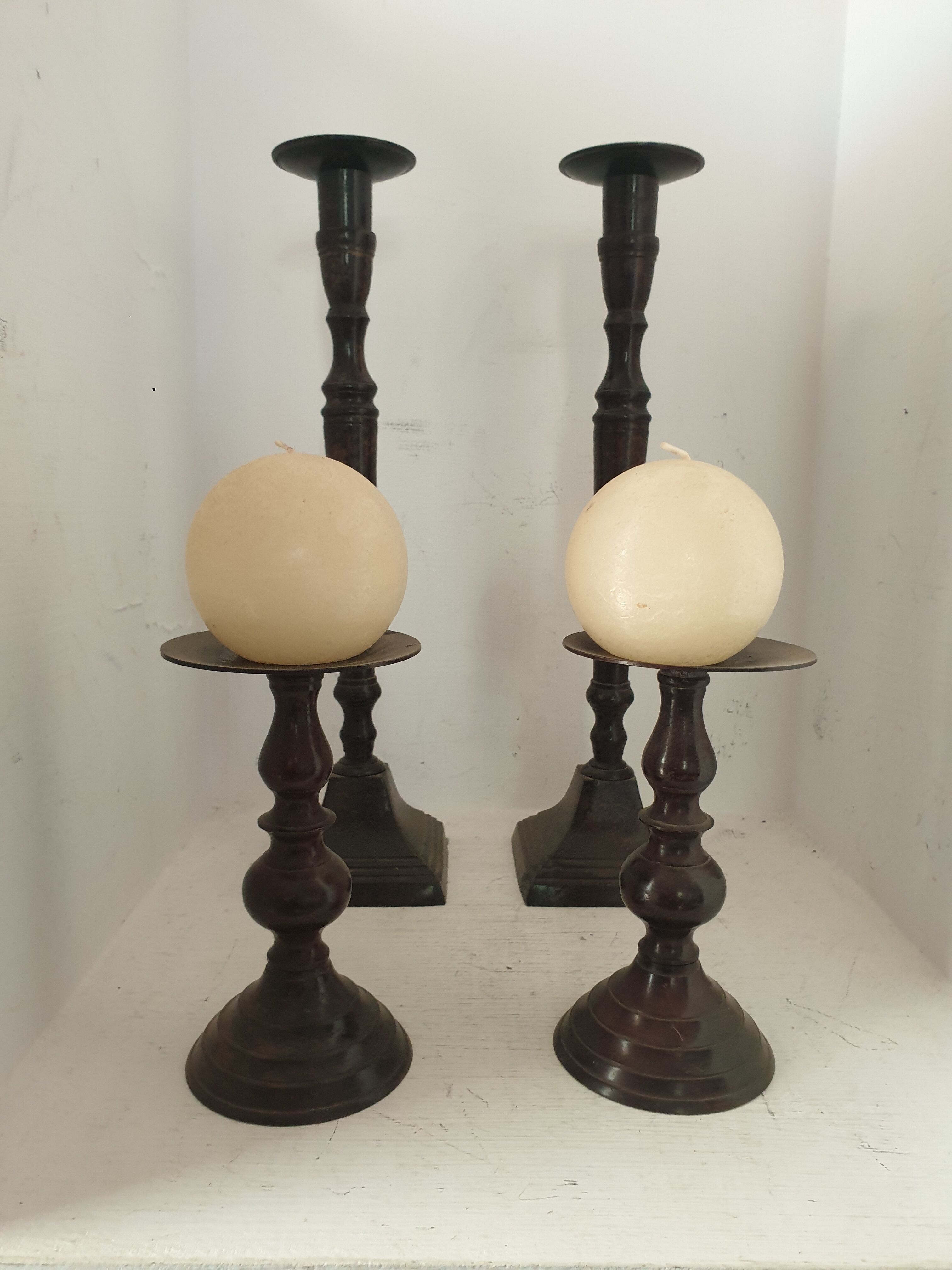 Two pairs of patinated brass candle holders
