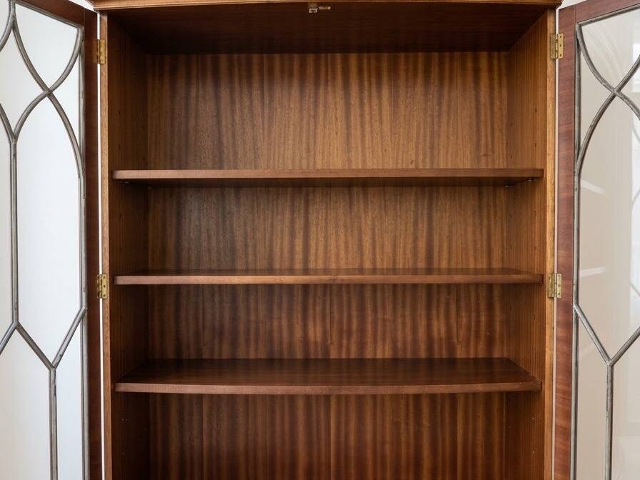 Classic English display cabinet in wood with glass doors.