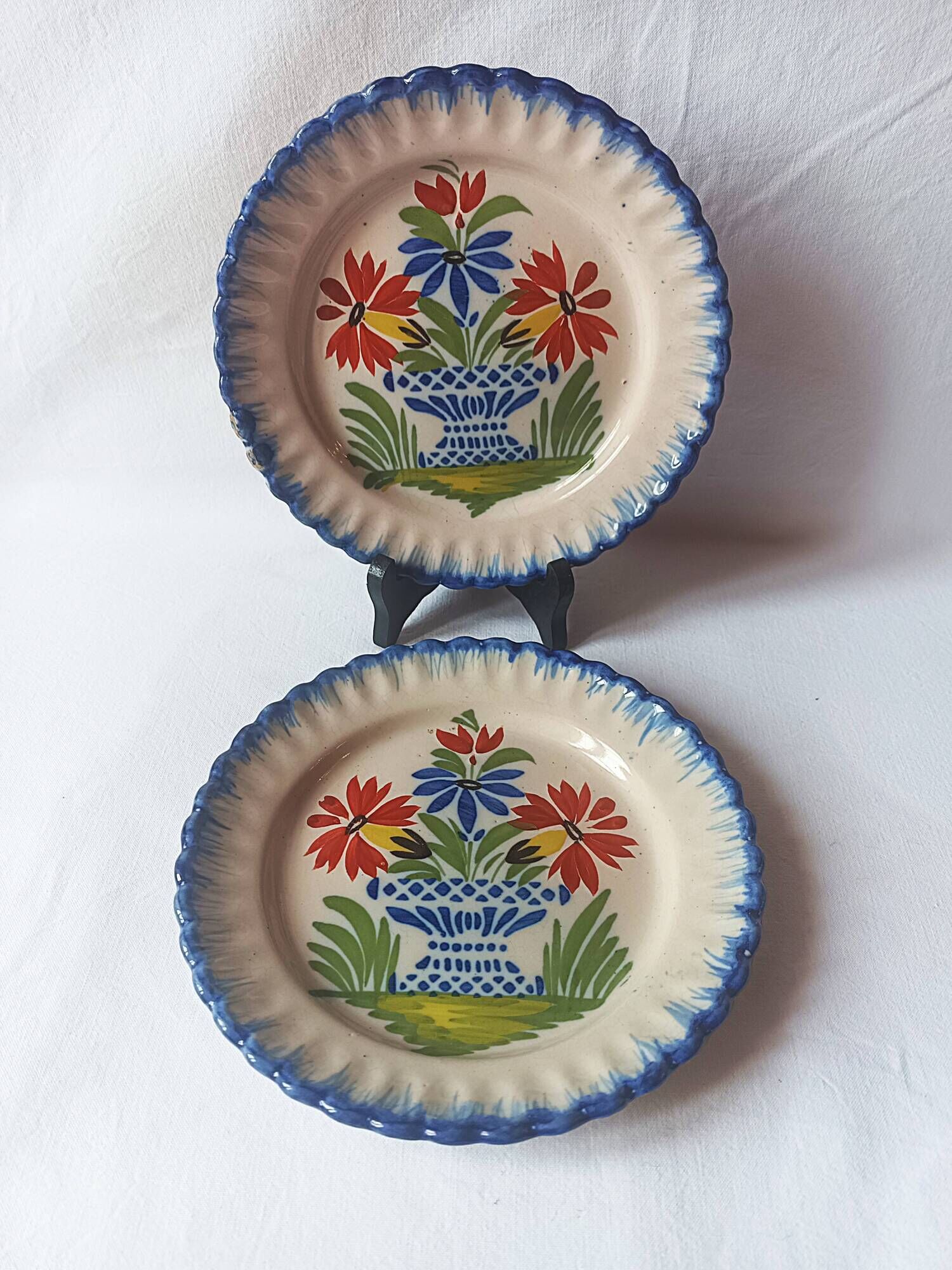 Pair of antique plates in popular earthenware with a floral basket decoration on the edge.