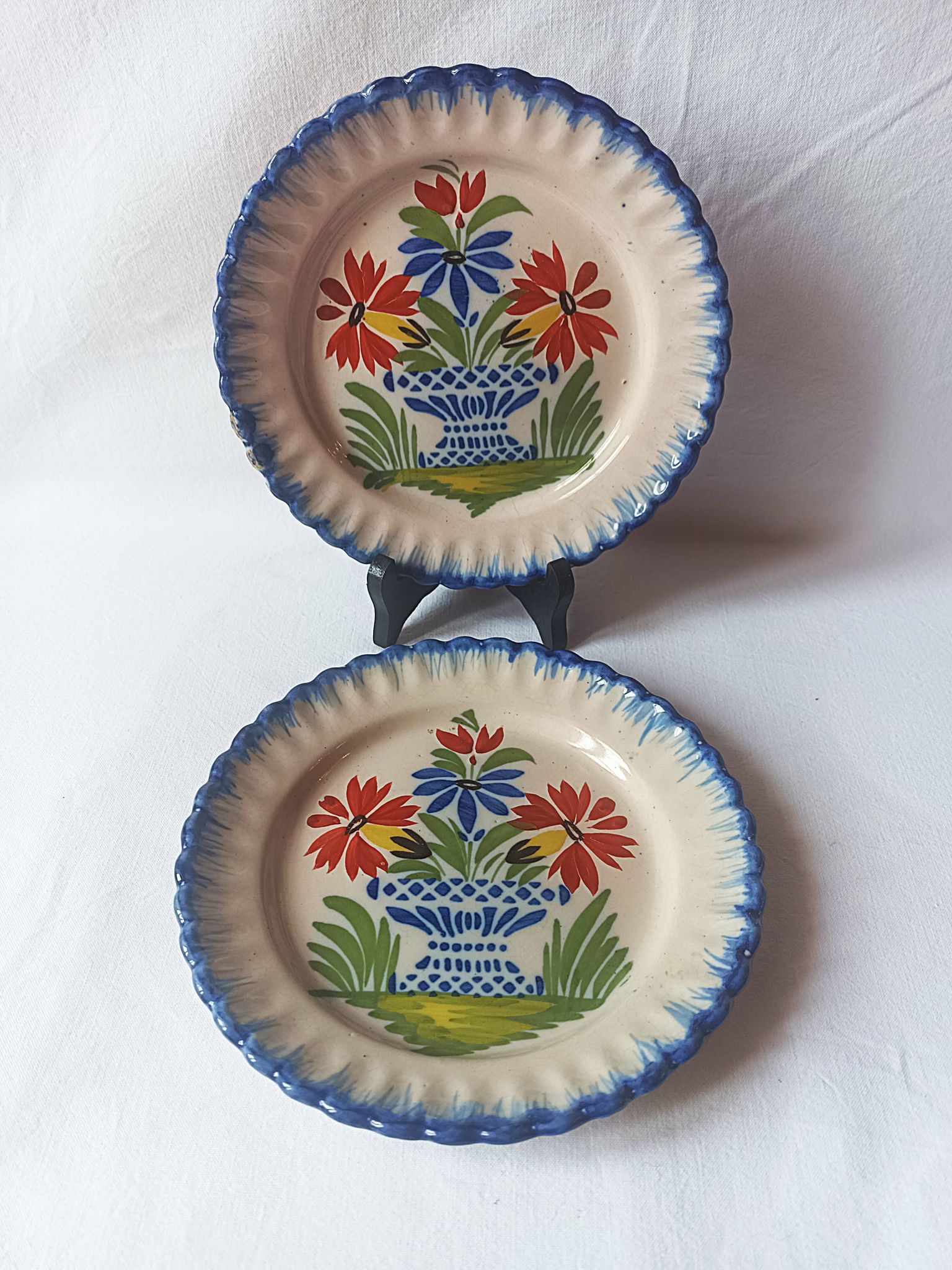Pair of antique plates in popular earthenware with a floral basket decoration on the edge.
