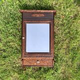 Old carved wooden medicine cabinet with beveled mirror