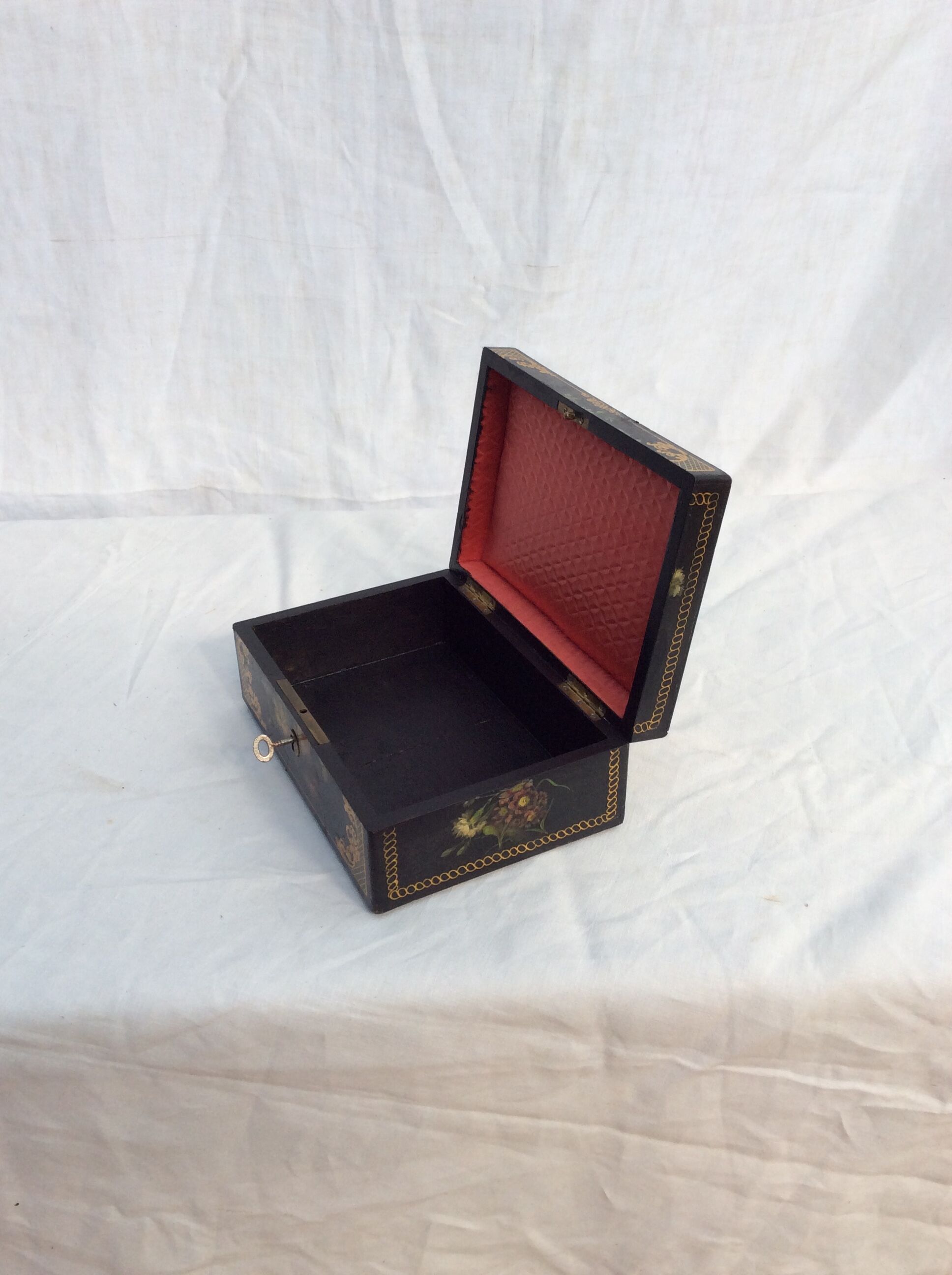 Old black wooden box adorned with roses with keys