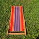 vintage wooden deck chair with red, blue, and yellow striped fabric